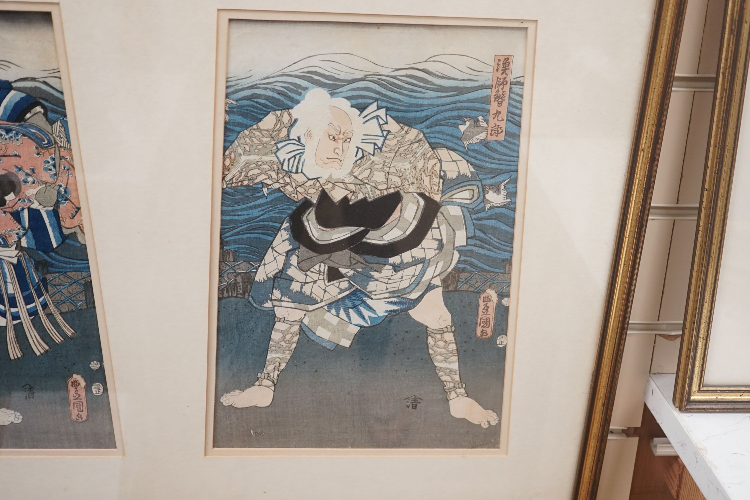 Kunisada, triptych of Japanese woodblock prints, Actors on stage beside the sea, each 35 x 24cm, framed as one